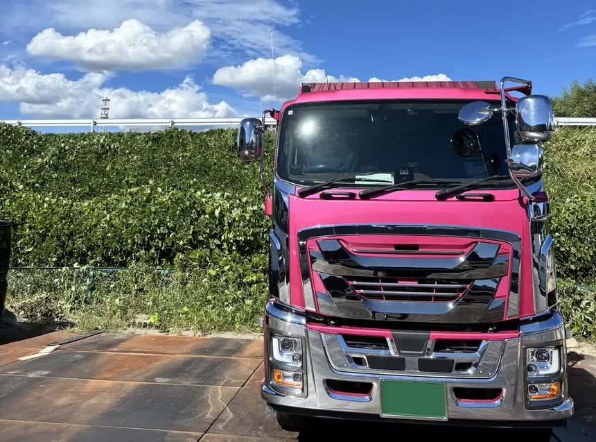 青空の下に停まる有限会社福田建材のダンプカー